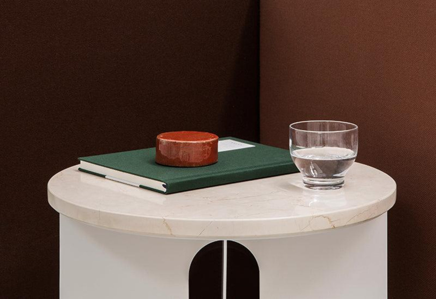  The Androgyne Side Table ﻿by ﻿Danielle Siggerud ﻿for ﻿Audo Copenhagen in ivory with crystal rose table top with book placed on its surface.