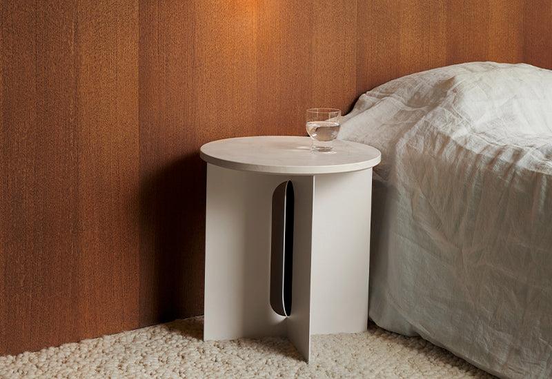 The Androgyne Side Table ﻿by ﻿Danielle Siggerud ﻿for ﻿Audo Copenhagen in ivory with crystal rose table top used as a bedroom side table.
