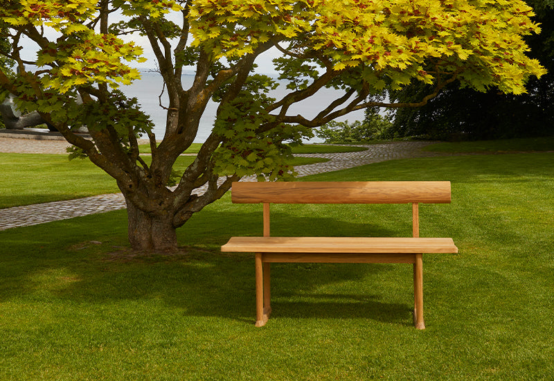  Fritz Hansen Banco bench by Hugo Passos under a tree.
